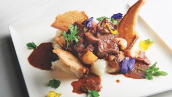 Beef Bourguignon Toast on a plate with colorful garnish