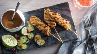 Chicken skewers with sauce and cucumbers